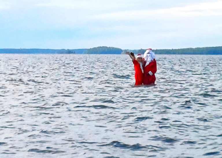 Joulupukki ja -muori ovat keskellä Puruvettä tutustumassa Mantsin matalikkoon, josta on lähimpään rantaan 2 km matkaa. Tällä kertaa vesi oli niin korkealla, että pariskunta käveli matalikolla vaikka vettä oli reiteen asti.